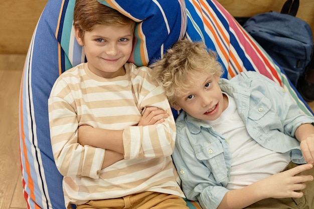 学校で色とりどりの豆袋の上に横たわっている2人の男の子