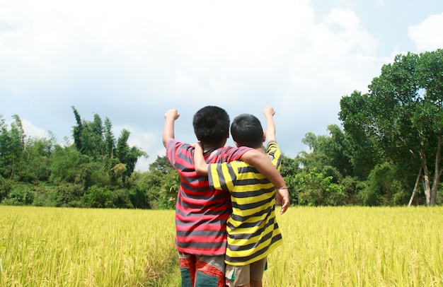 Two boys playing in rice farm.