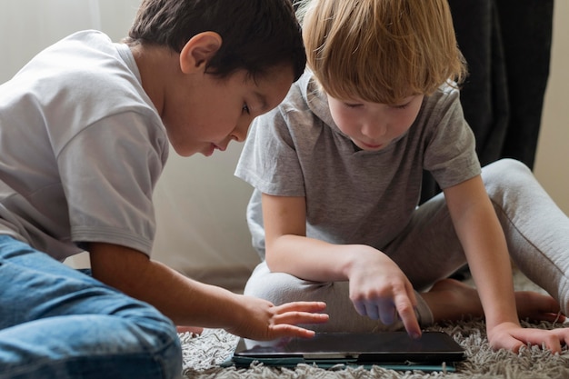 Two boys playing with tablet at home