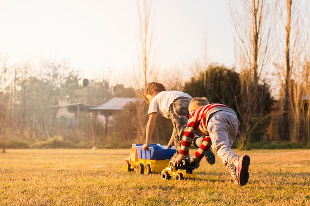 写真 青い草のおもちゃの車で遊んでいる2人の男の子