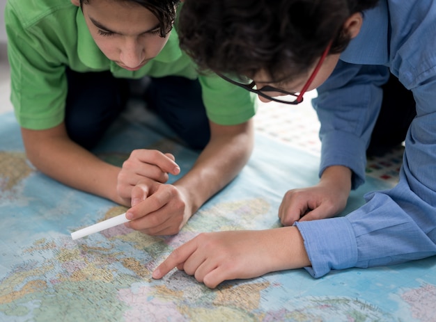 Two boys searching on world map