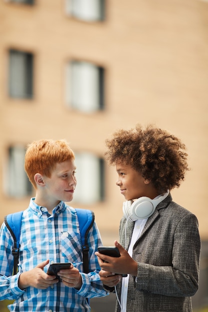 Photo two boys using their smart phones