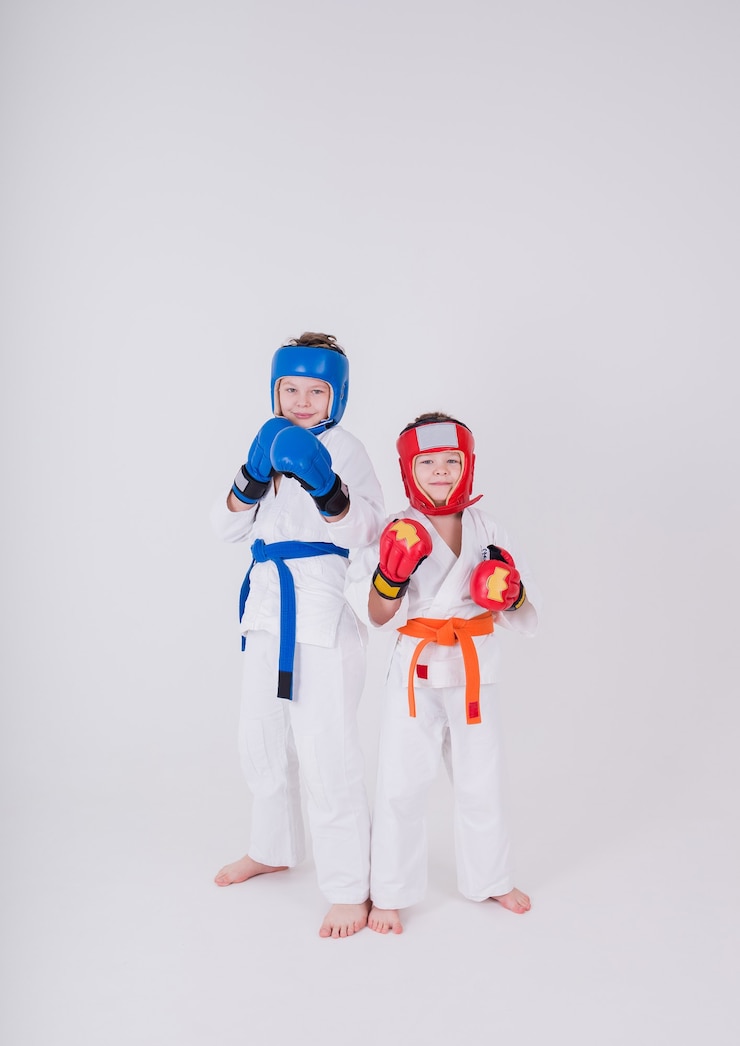 Photo 흰색 기모노, 헬멧 및 장갑에 두 소년은 흰색 배경에 포즈에 서