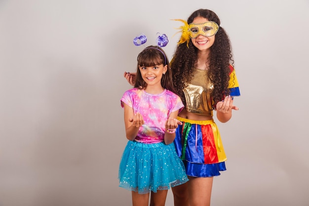 Two brazilian girls friends dressed in carnival clothes
inviting hands