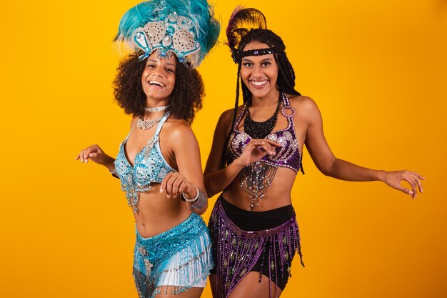 Two brazilian women friends in carnival clothes dancing and partying