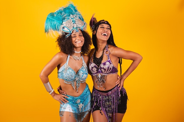 Foto due amiche brasiliane in vestiti di carnevale si mettono le mani sulla vita