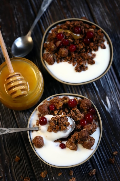 Two breakfast bowls with crunches honey berries and yogurt