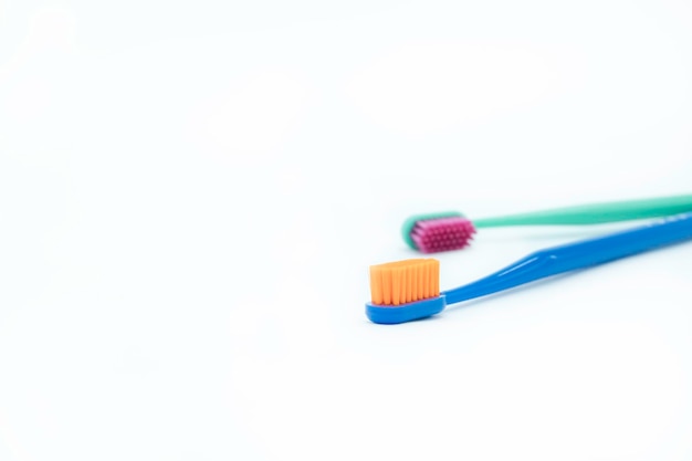 Two bright colored toothbrushes on a white background on the right closeup