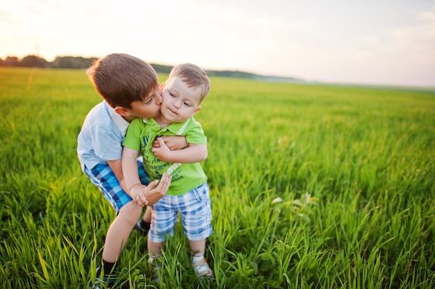 Two brothers in green grass field.