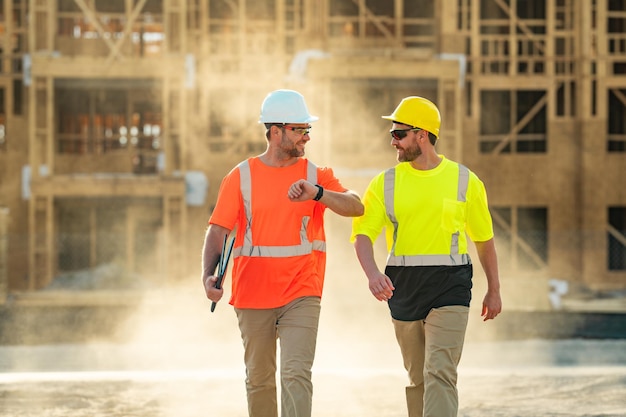 Two builders in a hard hat is busy working on a construction project at a site a builders workes in