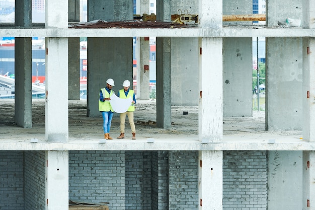 Two Builders Holding Construction Plans