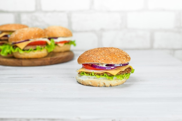 Photo two burgers with a hamburger on a wooden table.