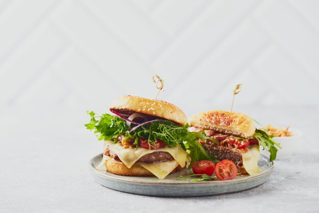 Two burgers with veal cutlet and herbs on wooden cutting board