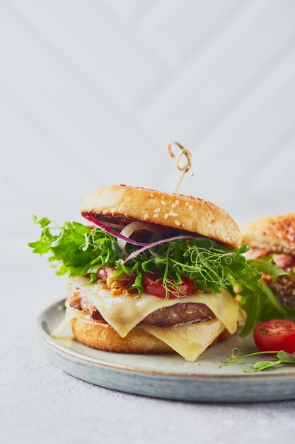 Two burgers with veal cutlet and herbs on wooden cutting\
board