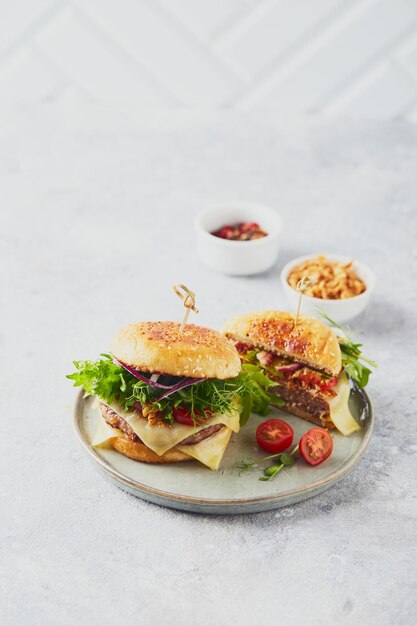 Two burgers with veal cutlet and herbs on wooden cutting board