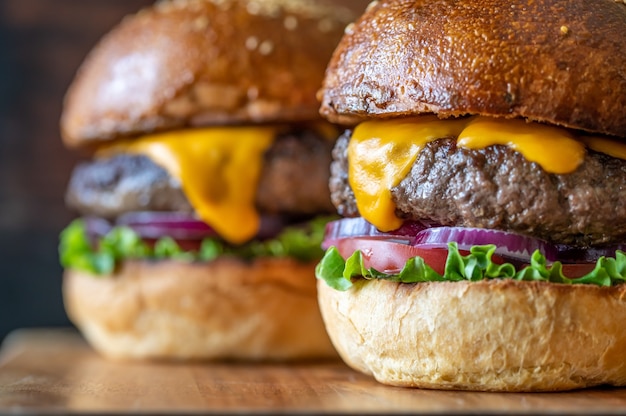 Two burgers on the wooden board close up