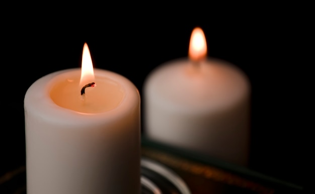 two burning candles isolated with black background
