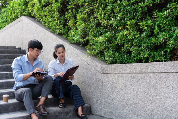 Two Business Colleagues Having Discussion new project business meeting outside office in an urban setting.