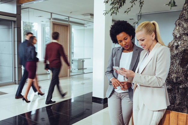 Two business colleagues standing with a digital tablet and discussing about work