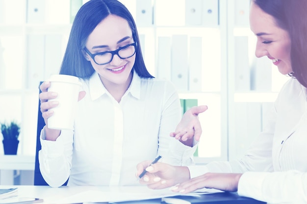 Two business partners in office with coffee