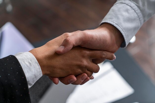 Two business partners shaking hands in office