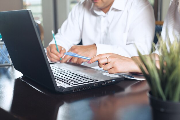 Two business partners sitting at a table together and working.