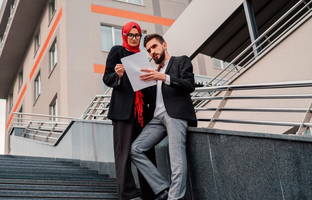 Фото Два деловых человека, деловой мужчина и деловая мусульманка в хиджабе, молодой деловой профессионал