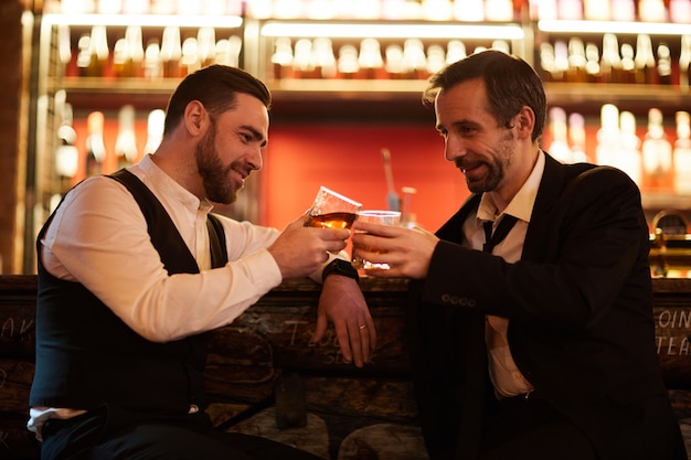 Два деловых человека празднуют в баре