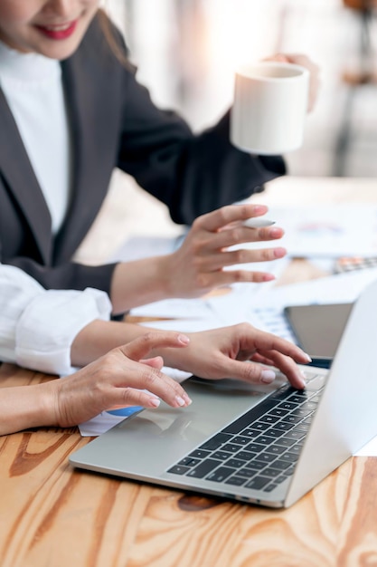 Photo two business people engaged in a discussion a financial report on laptop together young business professionals working together in a modern finance company