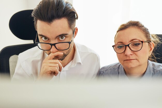 Foto due uomini d'affari imprenditori che lavorano sodo seduti davanti allo schermo del computer in ufficio persone al lavoro