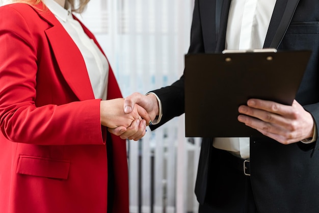 Two business people handshaking after successful partnership in modern office Successful deal completed