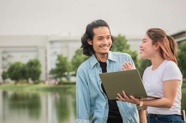 Two business people happy using computer technology outdoor