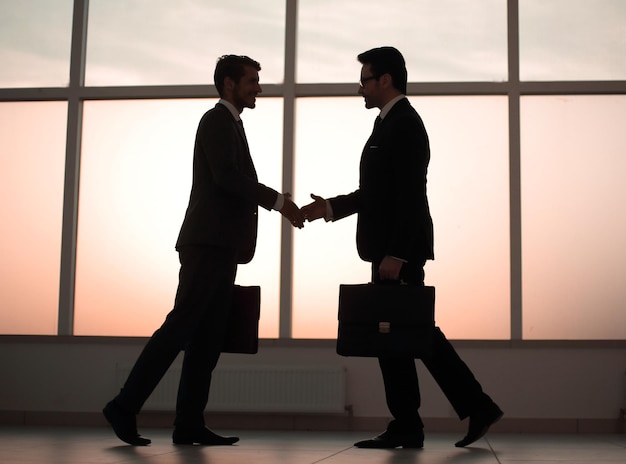 Two business people holding out their hands for a handshake