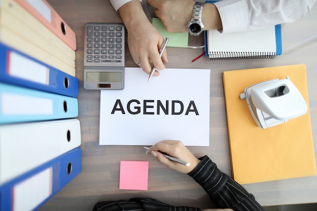 Two business people on office table with supplies