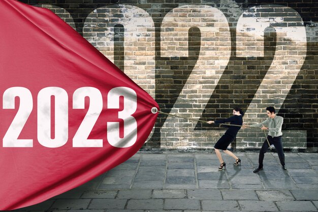 Photo two business people pulling numbers 2023