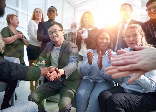 Two business people shaking hands while sitting in meeting room. Friendship concept