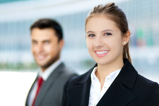 Two business people smiling in an urban setting