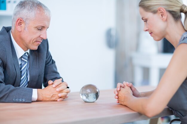 Two business people thinking with a crystal ball 