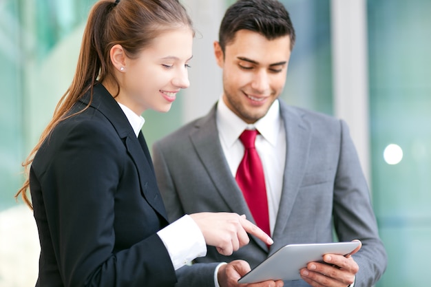 Two business people using a tablet in an urban setting