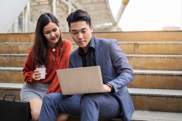 Two business people working at the stairs