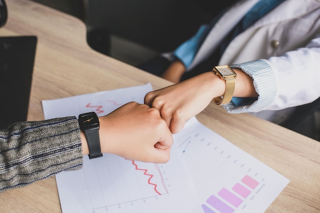 Two business woman doing fist bump at the office