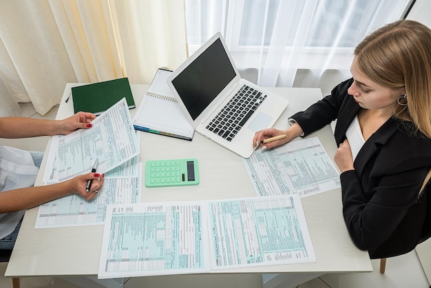 Two business woman filling tax form at office teamwork accounting