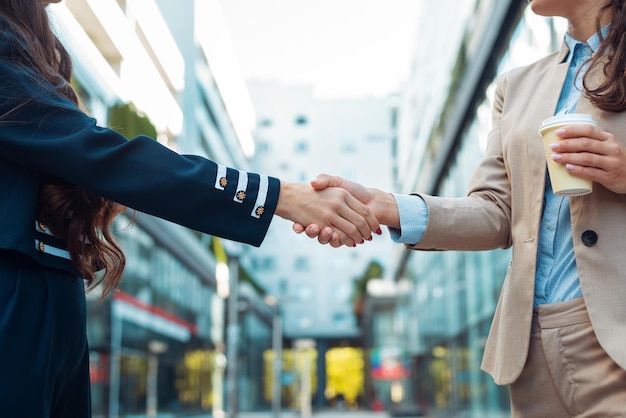 Two business woman shaking hands outdoor