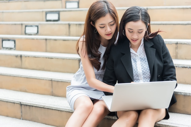 Two Business women consulting and using laptop at outdoor, Business and Technology concept