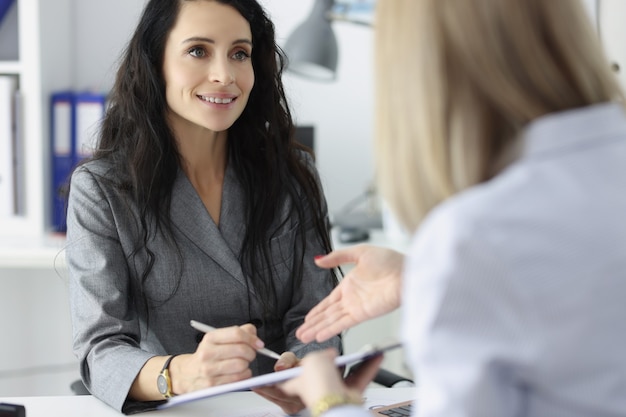 Two business women discussing at table in office teamwork with partners concept