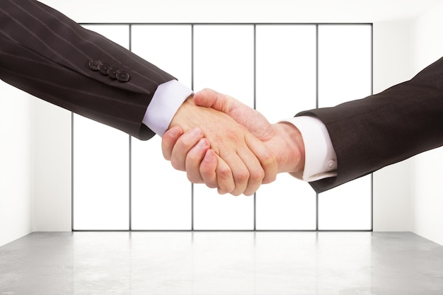 Two businessman handshake in loft style space