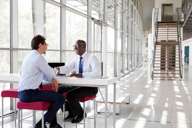 Two businessman shake hands during a meeting