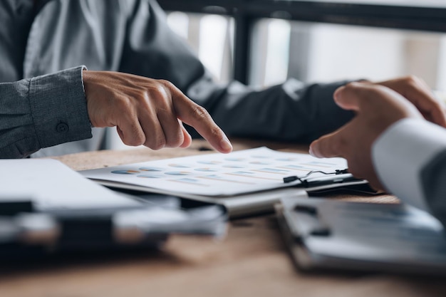 Two businessmen are reviewing monthly sales documents for analysis and marketing plans for more sales growth they are the founders of young companies cofounding startups Sales management concept