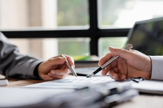 Two businessmen are reviewing monthly sales documents for analysis and marketing plans for more sales growth they are the founders of young companies cofounding startups Sales management concept