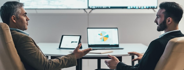 The two businessmen discussing at the table near a screen